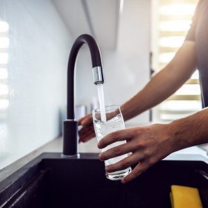 close-up-young-man-pouring-fresh-water-from-kitchen-sink-home-interior_232070-7659-transformed